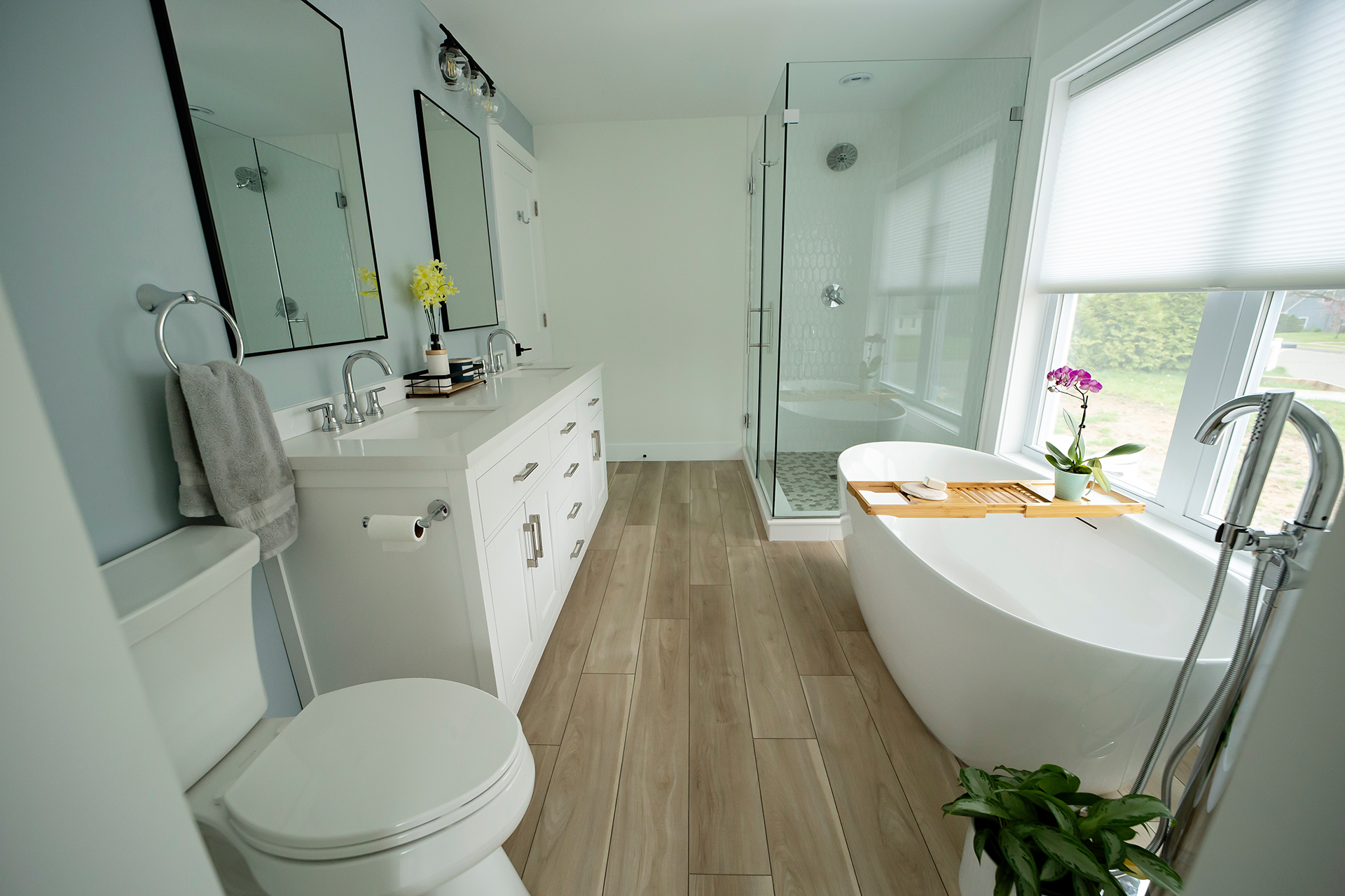 Soaking tub with tray and orchid near walk-in shower